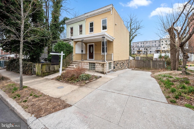 view of front of house featuring a porch and fence