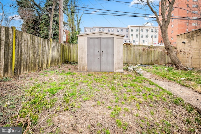 view of yard with a fenced backyard, a storage shed, and an outdoor structure