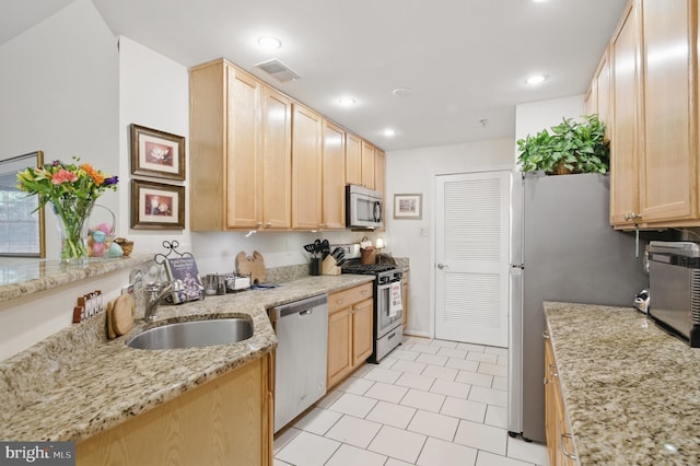 kitchen with visible vents, light brown cabinetry, a sink, appliances with stainless steel finishes, and light tile patterned floors
