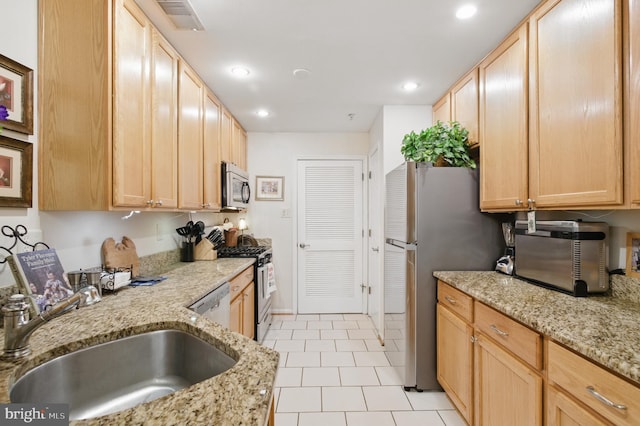 kitchen with a sink, light brown cabinetry, and stainless steel appliances