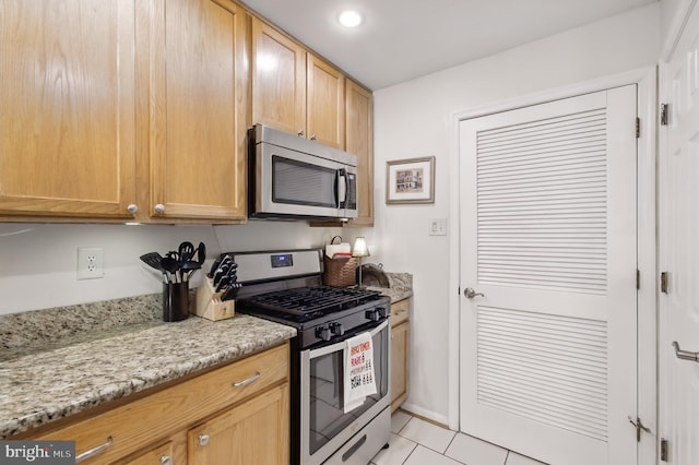 kitchen featuring light tile patterned floors, appliances with stainless steel finishes, light stone countertops, and recessed lighting