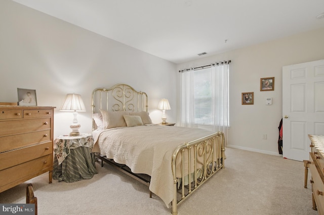 bedroom featuring baseboards, light carpet, and visible vents