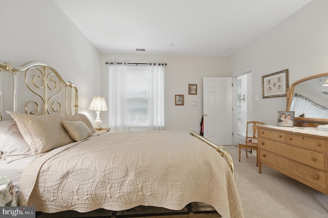 bedroom featuring visible vents and light colored carpet