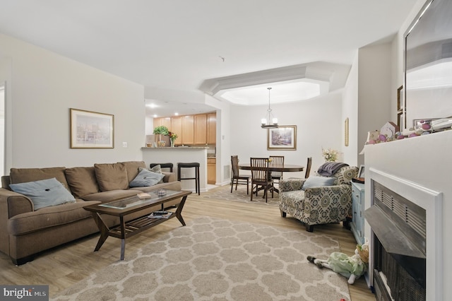 living room featuring light wood-style flooring and a chandelier