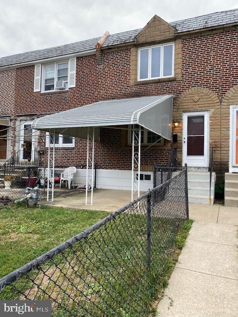 townhome / multi-family property featuring brick siding, entry steps, and fence private yard