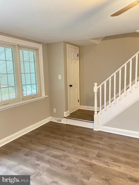 unfurnished room featuring wood finished floors, visible vents, and baseboards