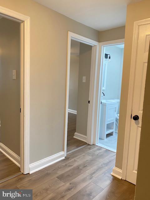 hall featuring baseboards and wood finished floors