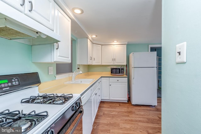 kitchen featuring under cabinet range hood, light wood-type flooring, white cabinets, white appliances, and a sink