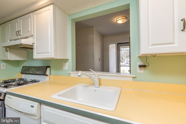 kitchen featuring under cabinet range hood, white cabinetry, range with gas cooktop, and a sink