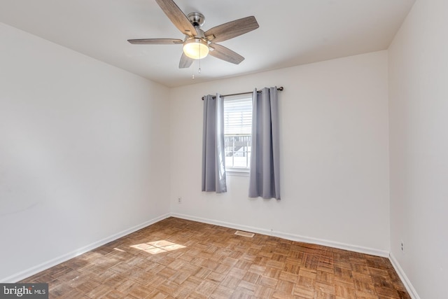 empty room with visible vents, ceiling fan, and baseboards