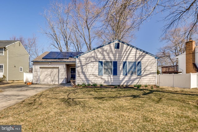 single story home featuring solar panels, concrete driveway, a garage, and fence