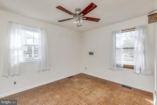 unfurnished room featuring visible vents, baseboards, and a ceiling fan