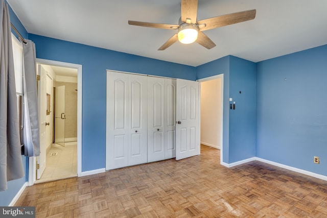 unfurnished bedroom featuring a closet, ensuite bath, baseboards, and a ceiling fan