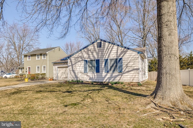 view of front of home with a garage, driveway, a front lawn, and fence