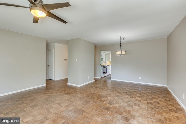 spare room featuring baseboards and ceiling fan