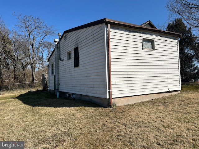 view of home's exterior featuring a lawn and fence