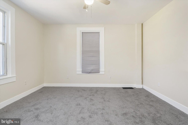 empty room featuring visible vents, baseboards, a ceiling fan, and carpet floors