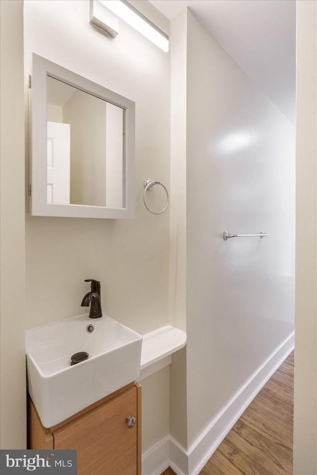 bathroom with baseboards, wood finished floors, and vanity