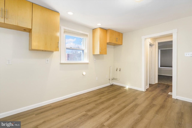 laundry area featuring recessed lighting, light wood-type flooring, and baseboards