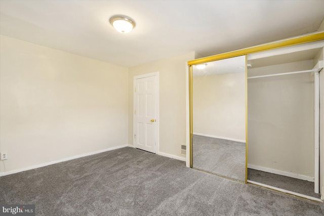 unfurnished bedroom featuring a closet, visible vents, baseboards, and carpet floors