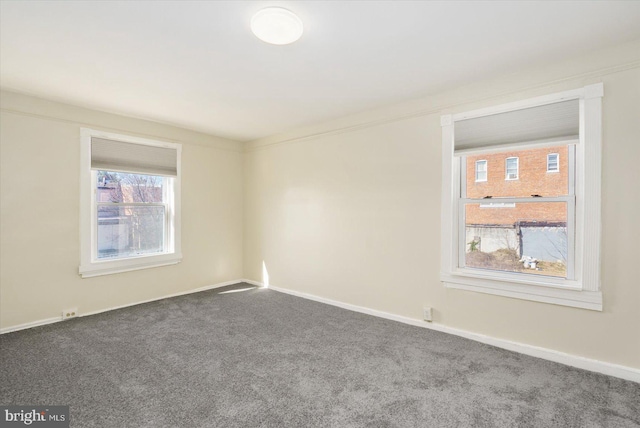 carpeted spare room featuring baseboards