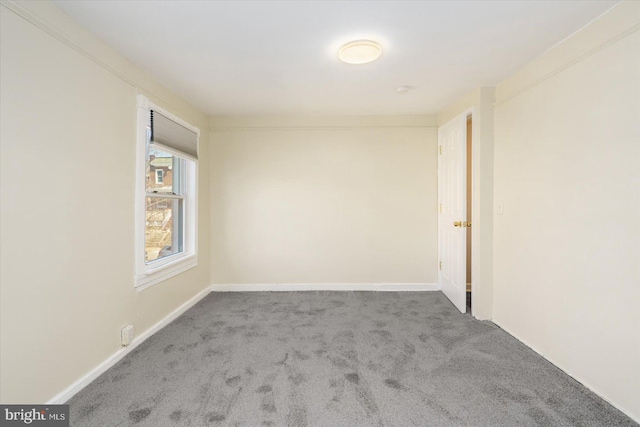 empty room featuring baseboards and carpet floors