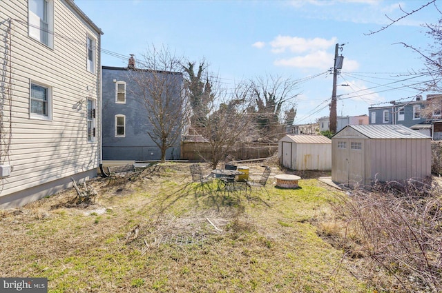 view of yard with a storage shed, an outbuilding, and fence