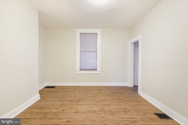 empty room featuring visible vents, baseboards, and light wood-style flooring