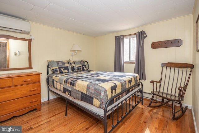 bedroom featuring light wood-style flooring and a wall mounted air conditioner