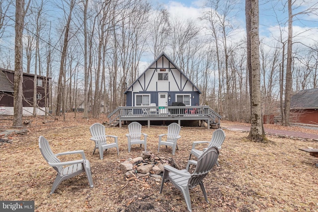 back of house featuring a wooden deck and a fire pit