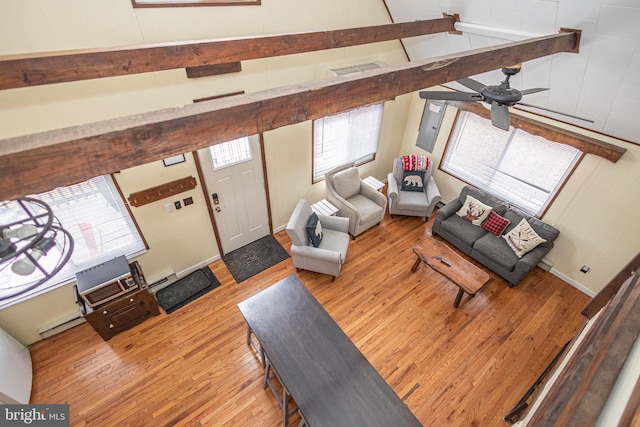 living area featuring lofted ceiling with beams, baseboards, wood finished floors, and ceiling fan