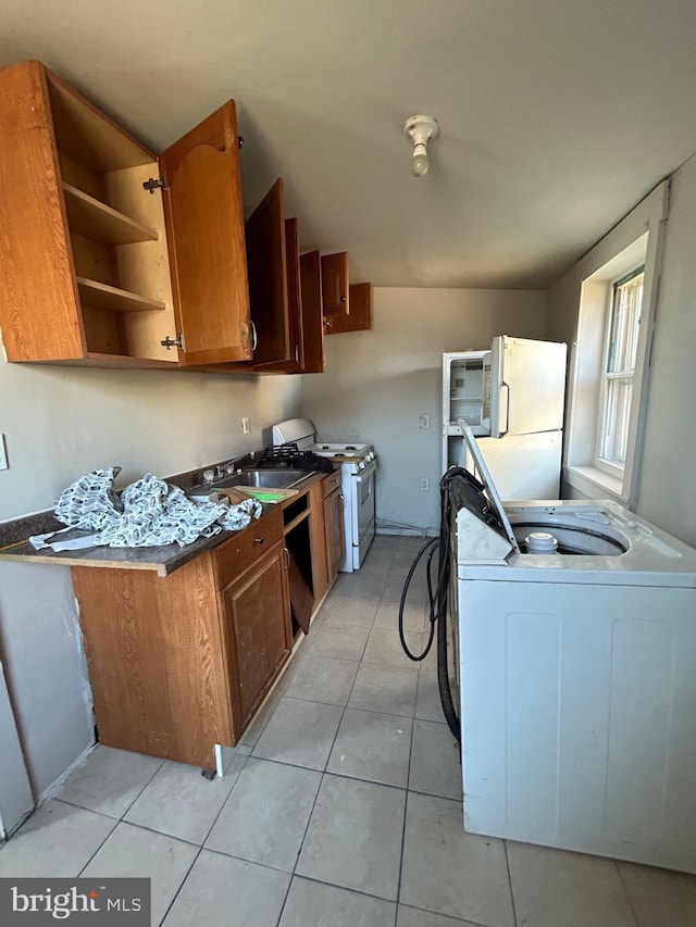 kitchen with white appliances, brown cabinetry, washer / dryer, open shelves, and light tile patterned flooring