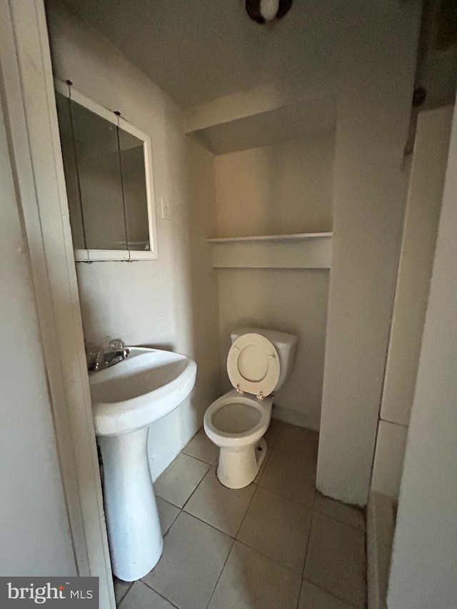 bathroom featuring toilet and tile patterned flooring