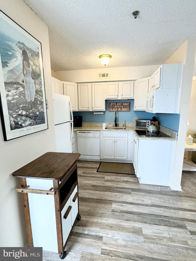 kitchen featuring light wood-style flooring, white cabinets, white appliances, a textured ceiling, and a sink