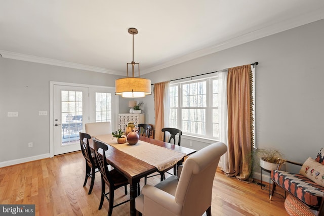 dining area with plenty of natural light, baseboards, light wood finished floors, and ornamental molding