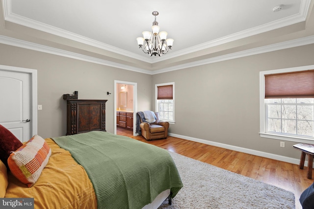 bedroom featuring connected bathroom, baseboards, a chandelier, ornamental molding, and wood finished floors