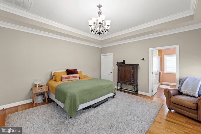 bedroom featuring visible vents, baseboards, light wood-style floors, and a chandelier