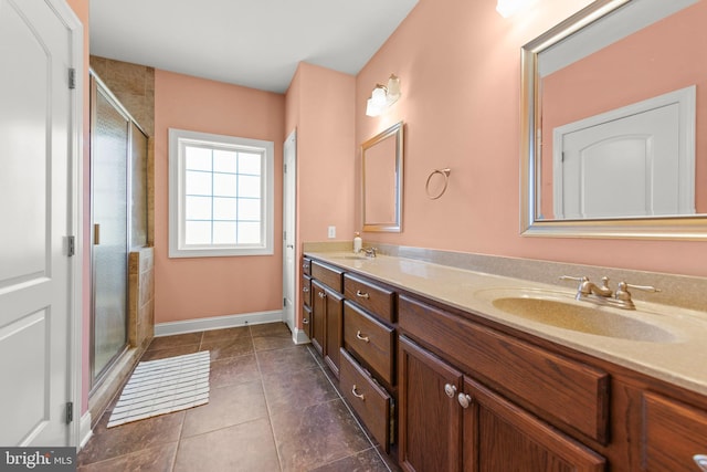 bathroom featuring double vanity, a stall shower, and a sink