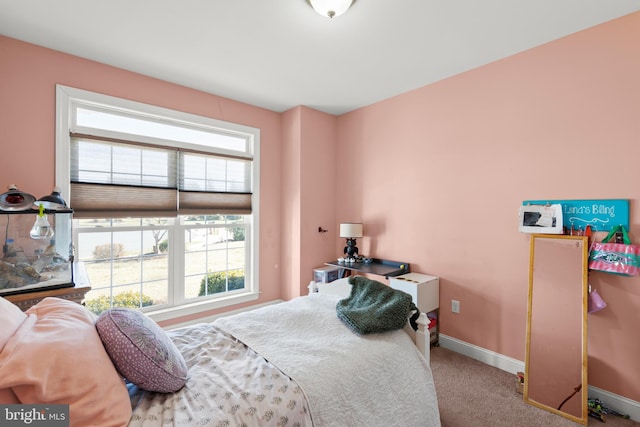 carpeted bedroom featuring multiple windows and baseboards