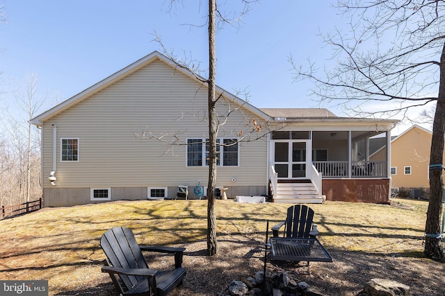 rear view of house with a yard and a sunroom