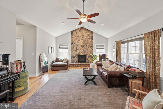 living area with a wealth of natural light, a fireplace, light wood-style floors, and ceiling fan