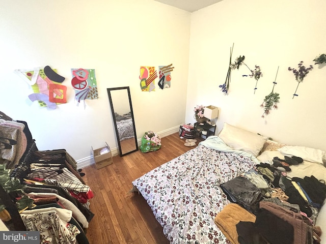 bedroom with baseboards and wood-type flooring