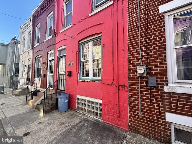 exterior space with entry steps and brick siding