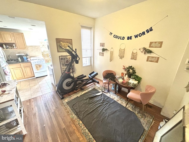 workout area featuring baseboards and light wood-style flooring