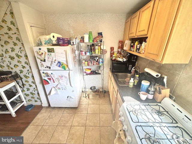 kitchen with light brown cabinets, backsplash, white appliances, wallpapered walls, and light tile patterned floors