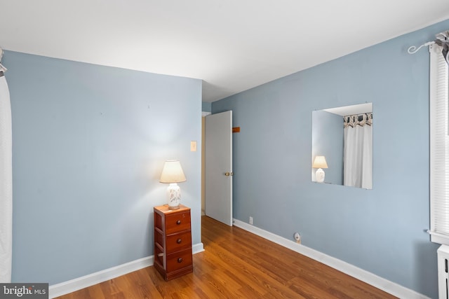 unfurnished bedroom with baseboards and wood finished floors