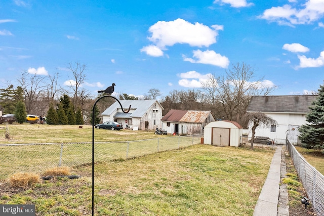 view of yard featuring a storage shed, an outbuilding, and a fenced backyard