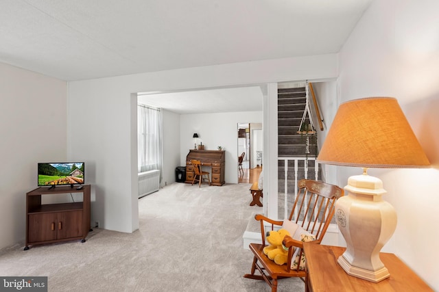 sitting room featuring stairway and carpet flooring