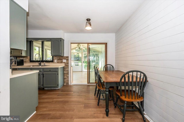 dining area featuring wood walls and dark wood finished floors