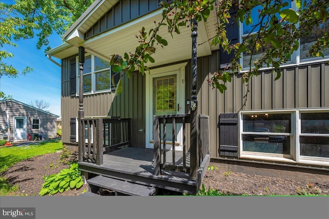 entrance to property with board and batten siding and a deck